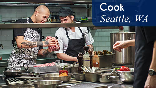 Image shows a cook mentoring a trainee in a kitchen. Now hiring a Cook for a recovery center in Seattle, WA