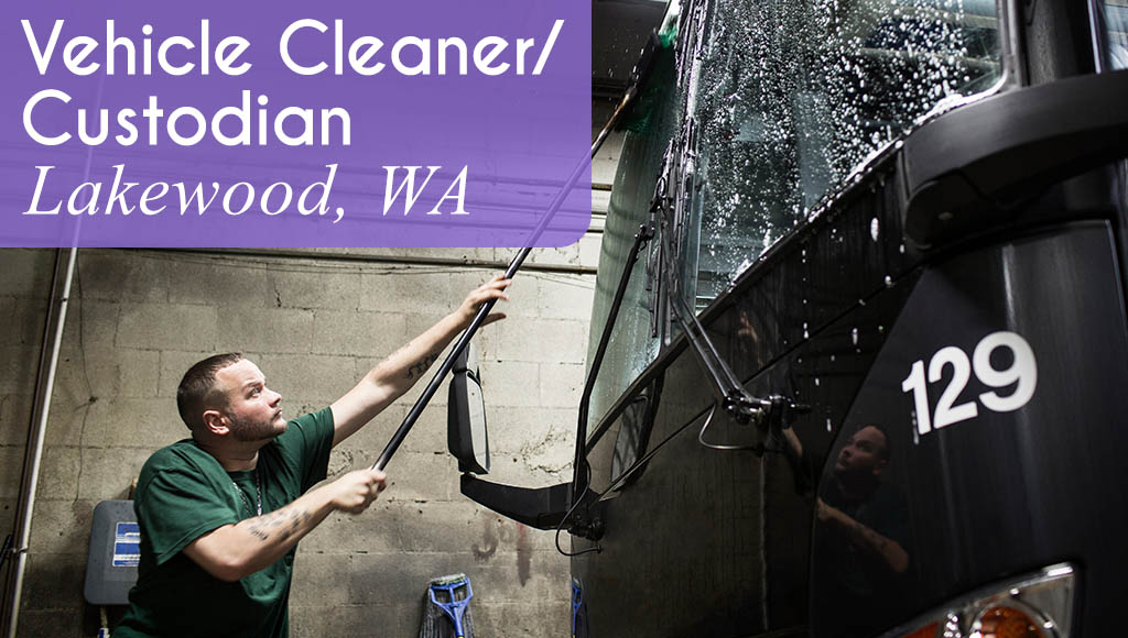 Image shows a man cleaning a bus with a long handle brush. Now hiring a Vehicle Cleaner / Custodian in Lakewood, WA.
