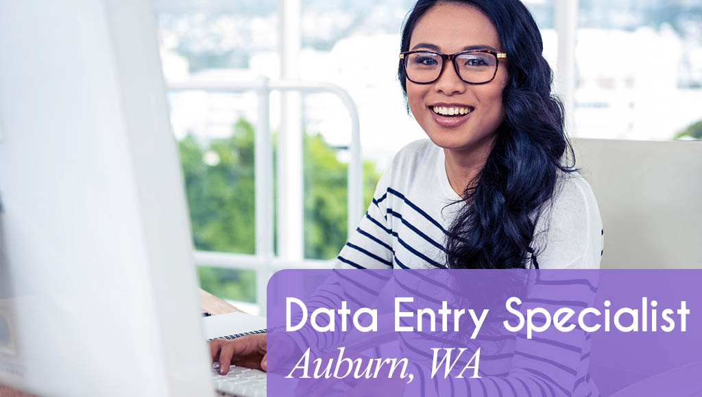 Image shows a woman smiling and typing at a computer. Now hiring a Data Entry Specialist in Auburn, WA.