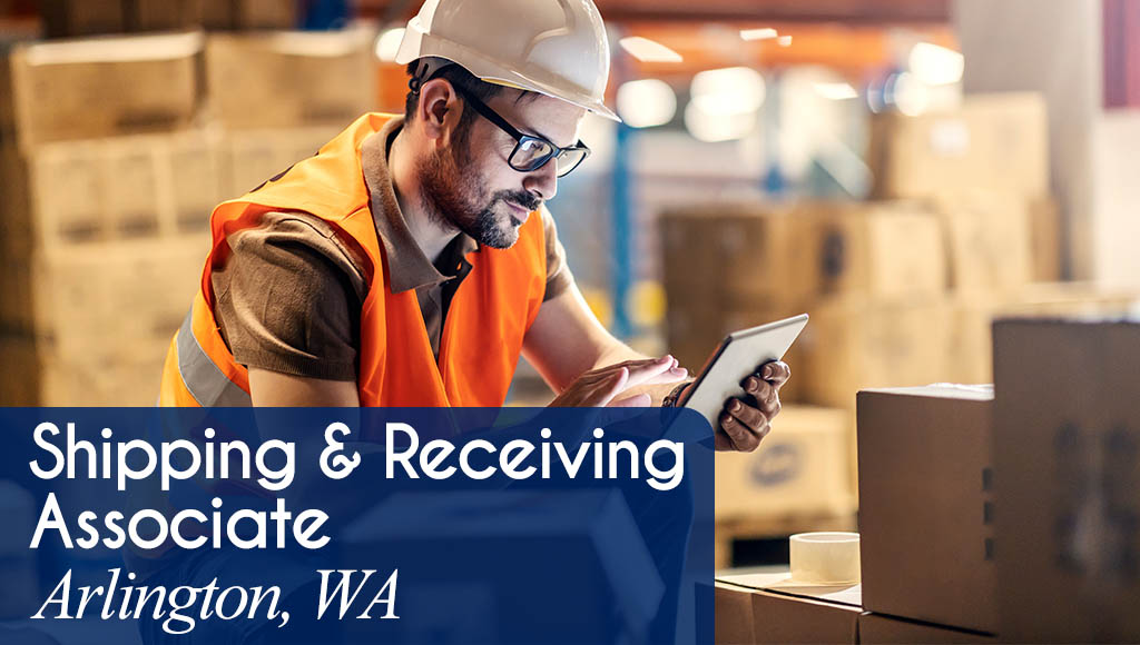Image shows a man wearing safety gear in a warehouse environment with boxes and typing on a tablet. Now Hiring a Shipping & Receiving Associate in Arlington, WA. All StarZ Staffing.