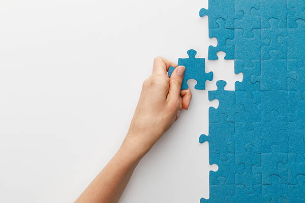 Tailor your resume to show them you're a good fit. Image shows a hand perfectly matching a puzzle piece to an open space in a puzzle. All StarZ Staffing.