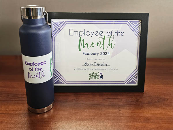 Image is a photo of Olivia's framed Employee of the Month certificate and water bottle for February 2024. All StarZ Staffing.